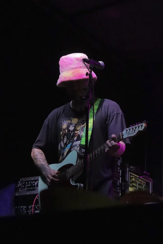 Guitarist on stage under purple light