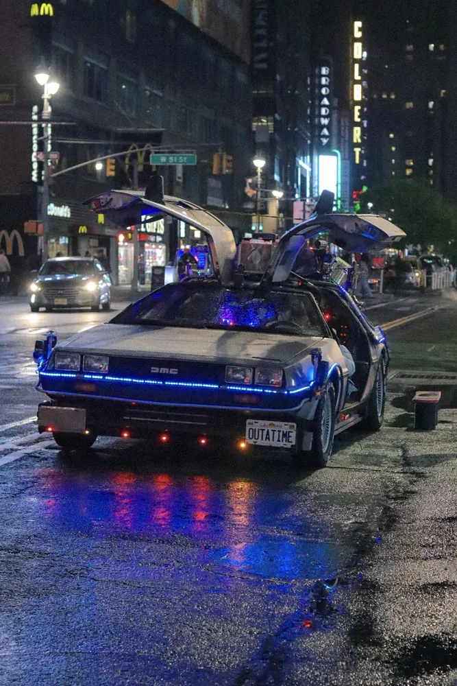 DeLorean glowing on a wet city street at night