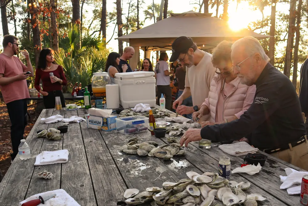 Guests shucking oysters at an outdoor event